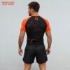 Back view of black and orange Canada-themed sublimated rash guard with maple leaf outline for No-Gi grappling and MMA