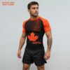 Front view of Canada-inspired sublimated rash guard with black and orange maple leaf design for BJJ and MMA training