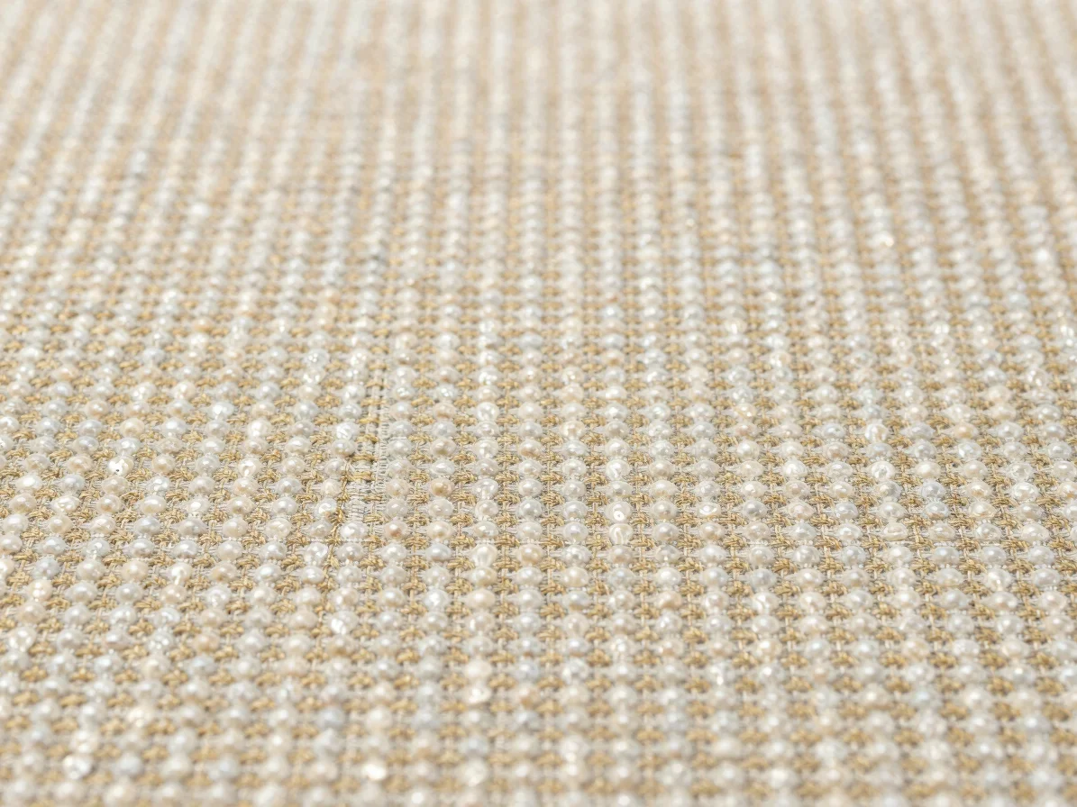Close-up studio photograph of woven fabric swatches showing pearl